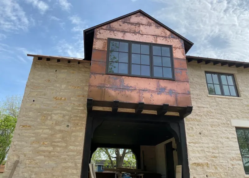 Copper metal panel facade on a stone building for Metal Roof Coating in Groesbeck